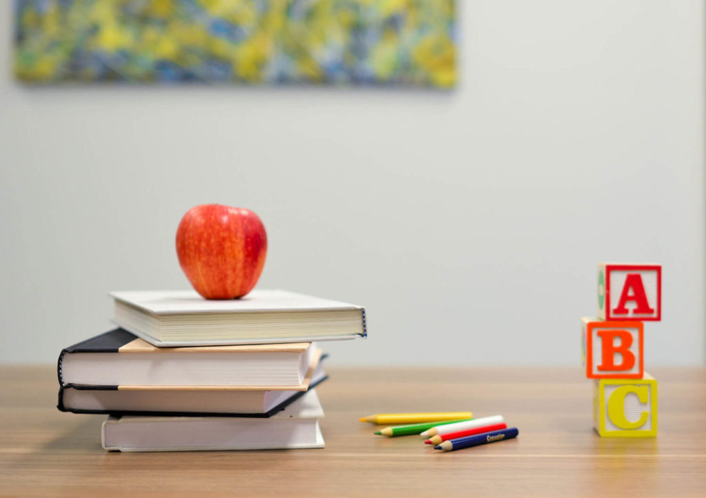 A book on desk with apple and ABC blocks - Photo by Element5 Digital on Unsplash