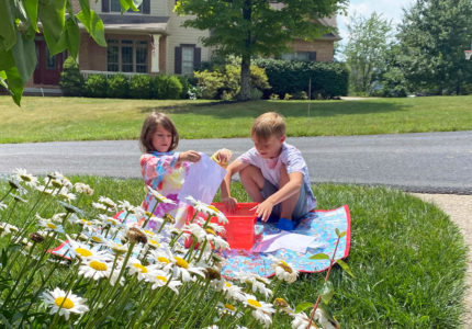 Kids experimenting with paint and art outside in the summer