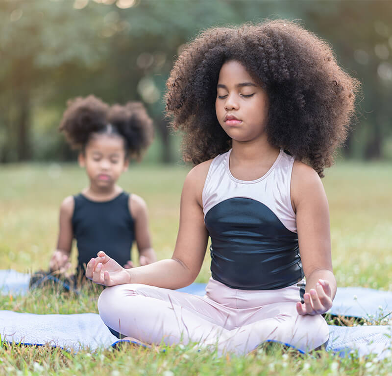 Children doing yoga in park. Remain calm and learn to reset yourself; this can help your kids recharge.